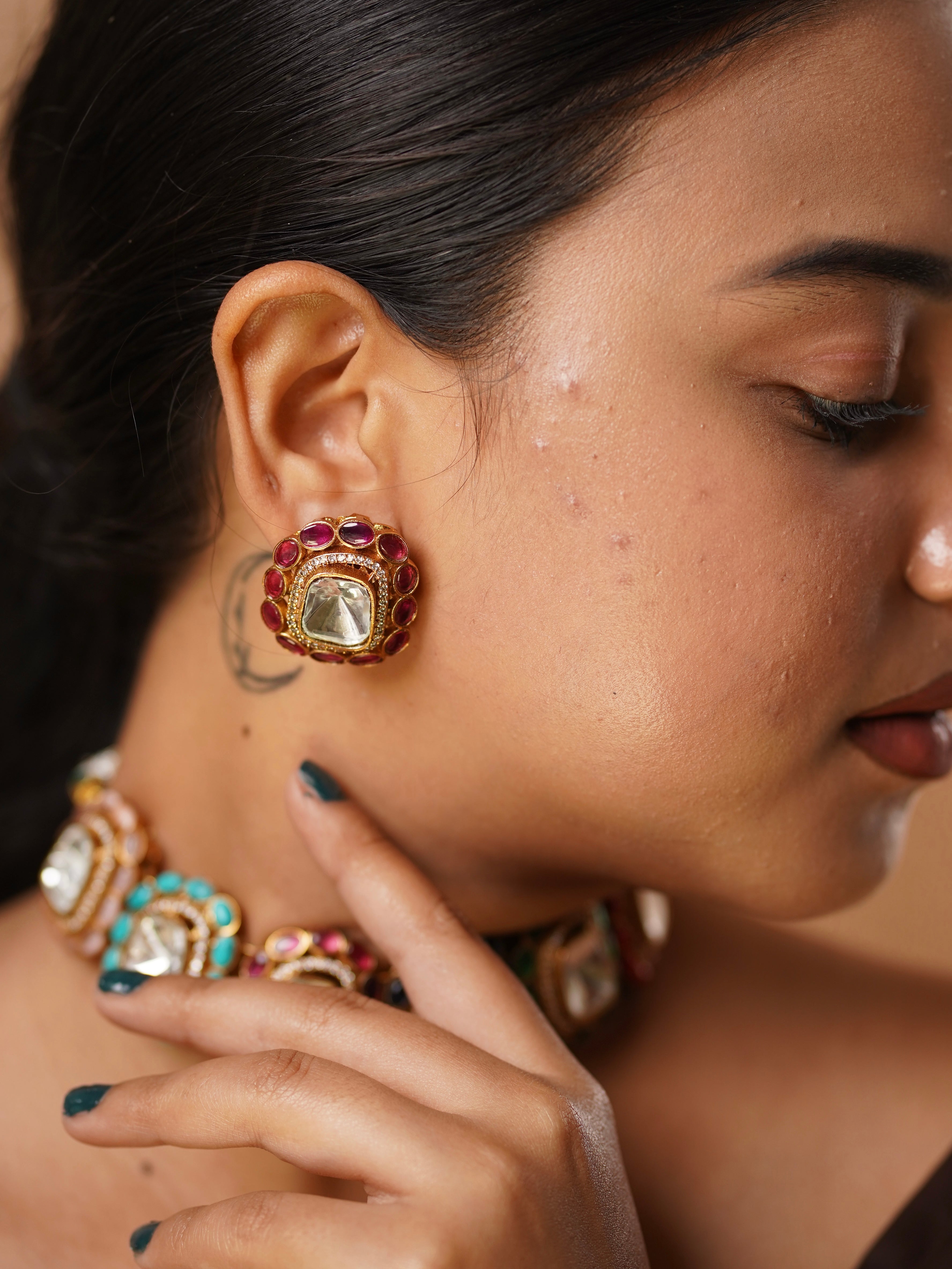 Angled view of choker set with ruby, sapphire, and turquoise stones in a statement mirror finish